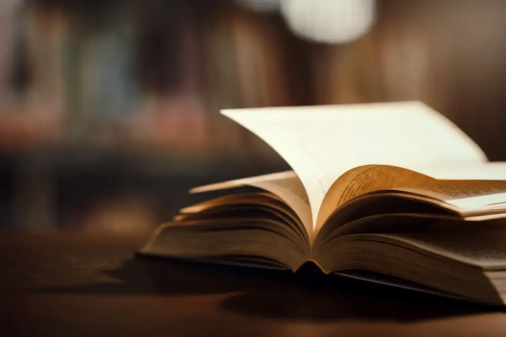 A imagem mostra um livro aberto, simbolizando a pesquisa e o registro histórico da psicologia clínica histórico-cultural no Brasil. Neste post, exploramos as raízes dessa abordagem, desde os primeiros debates nos anos 2000 até o pioneirismo da profa. Ana Ignez Belém Lima na Universidade Estadual do Ceará. Destacamos contribuições fundamentais, como os estudos de González-Rey e Delari Jr, e o papel do LADES-UECE na implementação de estágios clínicos e disciplinas específicas. A história dialética da área revela esforços coletivos para consolidar uma clínica alinhada à teoria vigotskiana, combatendo apagamentos e fortalecendo a formação de profissionais. Psicologia clínica histórico-cultural no Brasil é construída por vozes que resistem ao obscurantismo e celebram a práxis transformadora. Junte-se a nós para aprofundar esse legado!