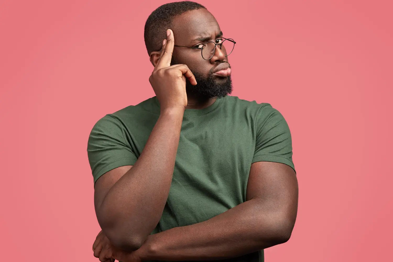 O raciocínio clínico na Psicologia Histórico-Cultural (PHC). Foto de homem negro, forte, de cabelos raspados, barba curta, vestindo óculos preto redondos e camiseta verde, presentando uma pessoa pensando de braços cruzados. O raciocínio clinico na PHC parte da análise da história de vida e da situação social de desenvolvimento do sujeito. Diferente de modelos padronizados, utiliza o Projeto Terapêutico Singular (PTS) como instrumento central, guiando intervenções contextualizadas e éticas. Na PHC, instrumentos e signos são usados de forma intencional para promover o desenvolvimento psíquico. A abordagem propõe uma clínica crítica, sensível à realidade concreta do paciente e comprometida com a transformação e o cuidado real.